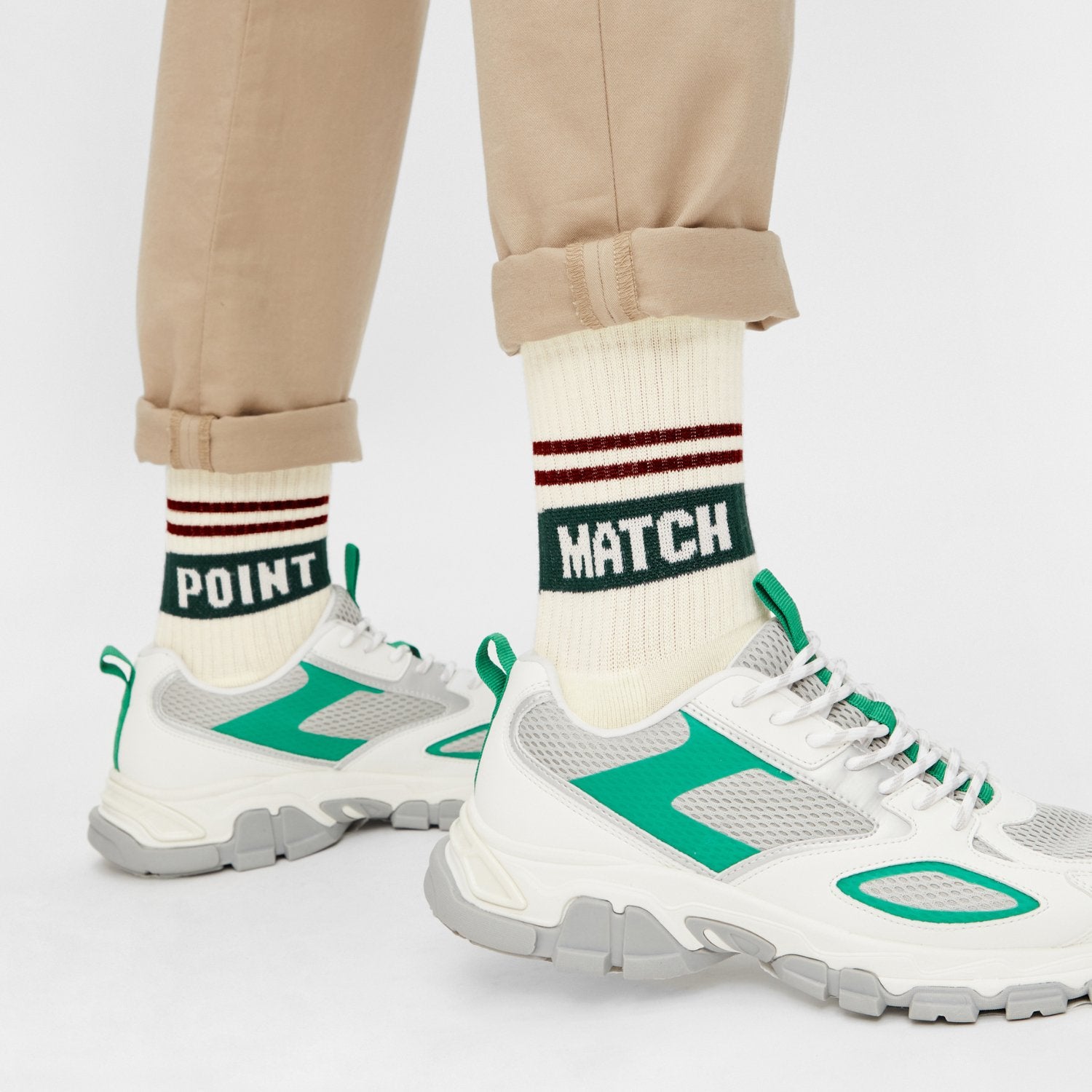 Model trägt Naturweiße Tennissocken "Match Point" mit dunkelroten Streifen und Schriftzug "Match Point" mit Sneakern - Natural Vibes Clothing