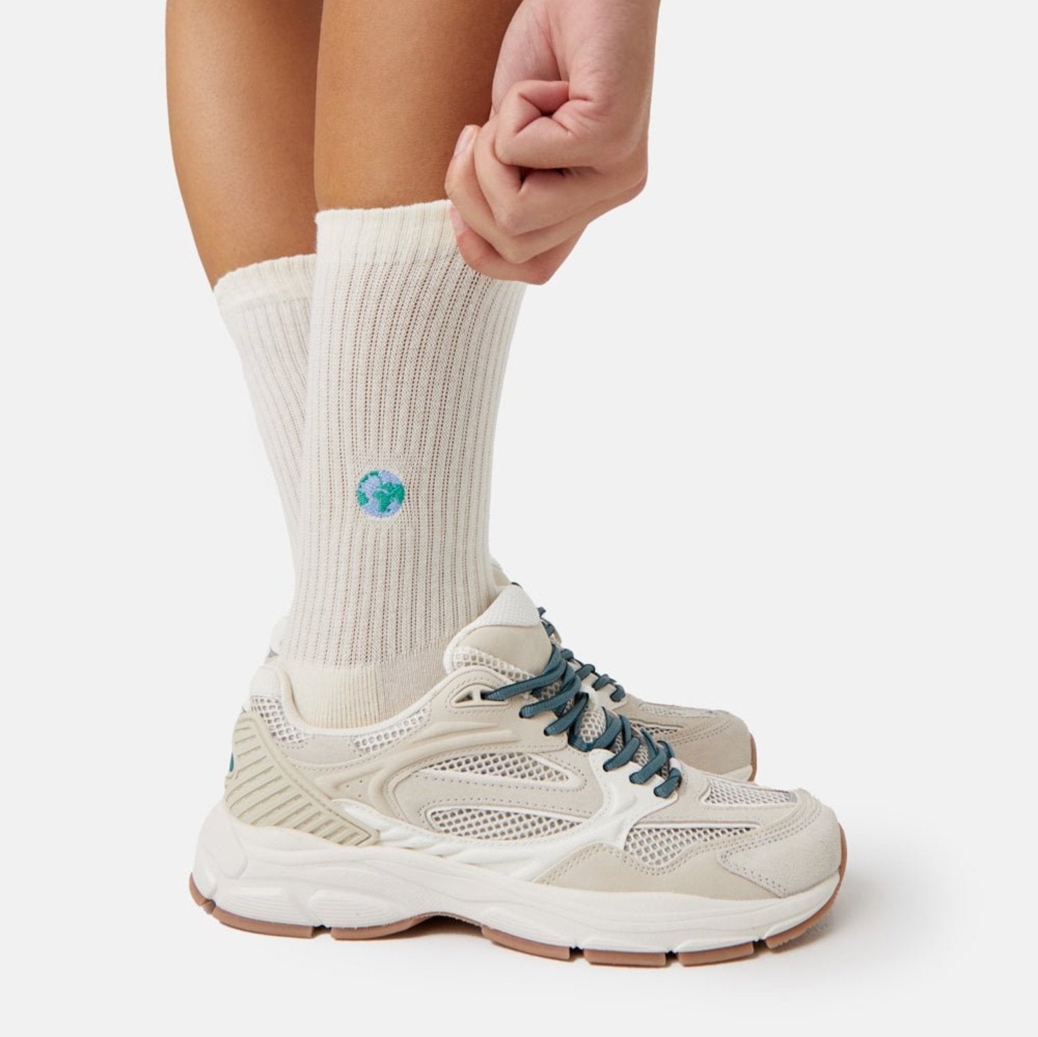 Welt Tennissocken - Natural Vibes Clothing. Naturweiße Bio-Tennissocken mit Globus-Stickerei kombiniert mit Sneakern.