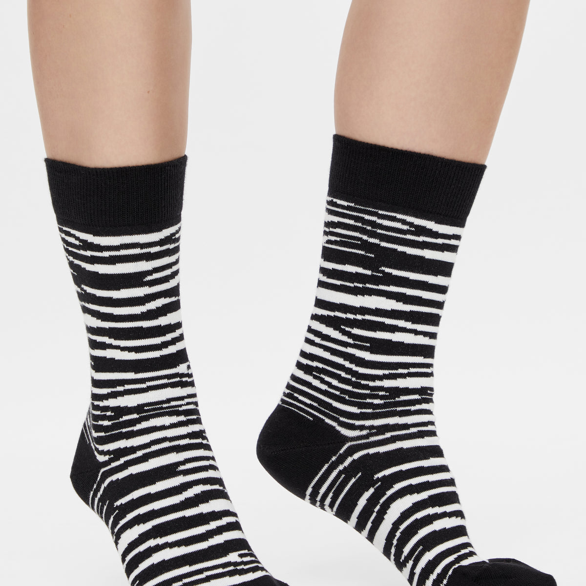 Schwarz-weiße Zebra Socken mit klassischem Animal Print am Fuß getragen.