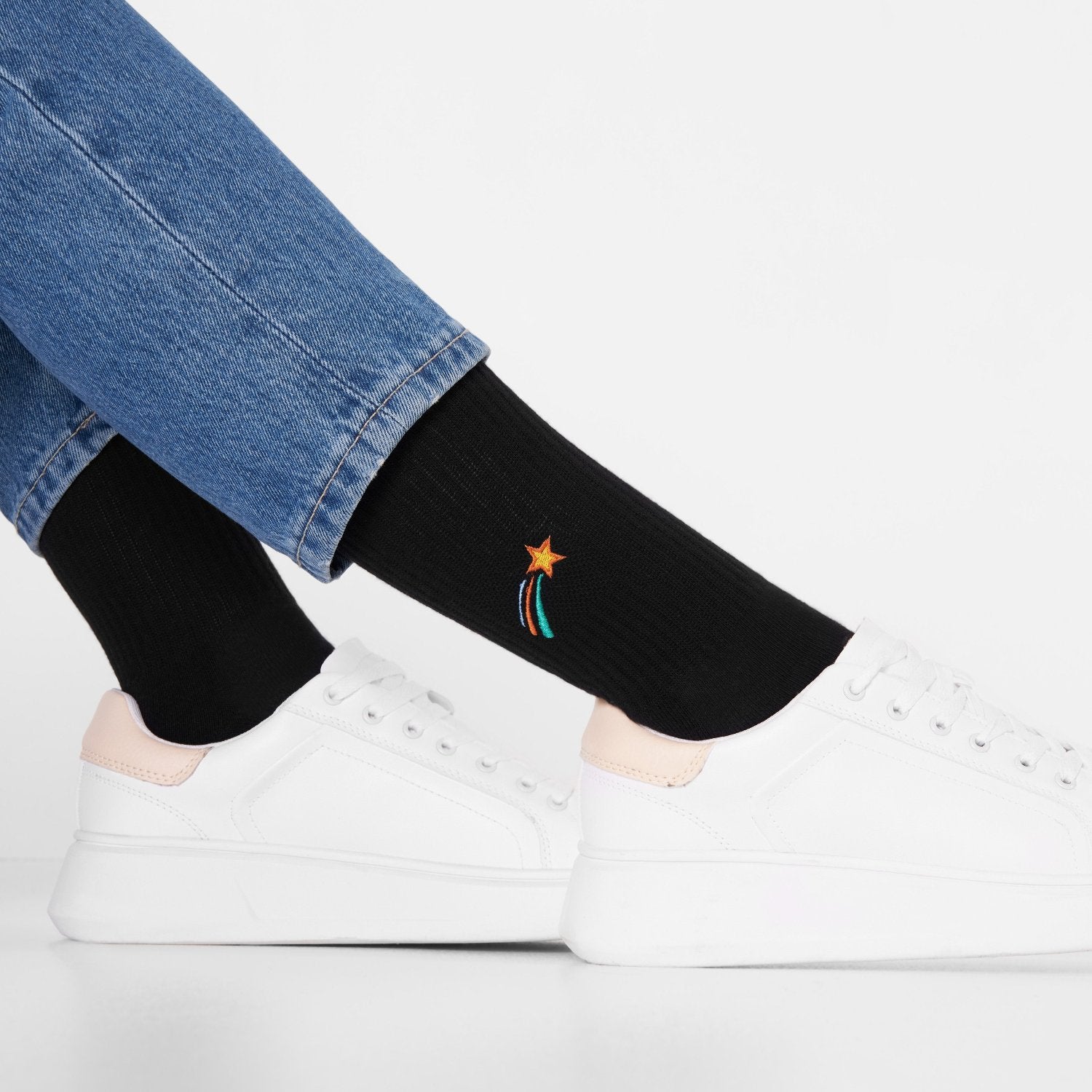 Shooting stars Tennissocken - Natural Vibes Clothing. Schwarze Bio-Tennissocken mit mehrfarbiger Sternschnuppen-Stickerei kombiniert mit Sneakern.
