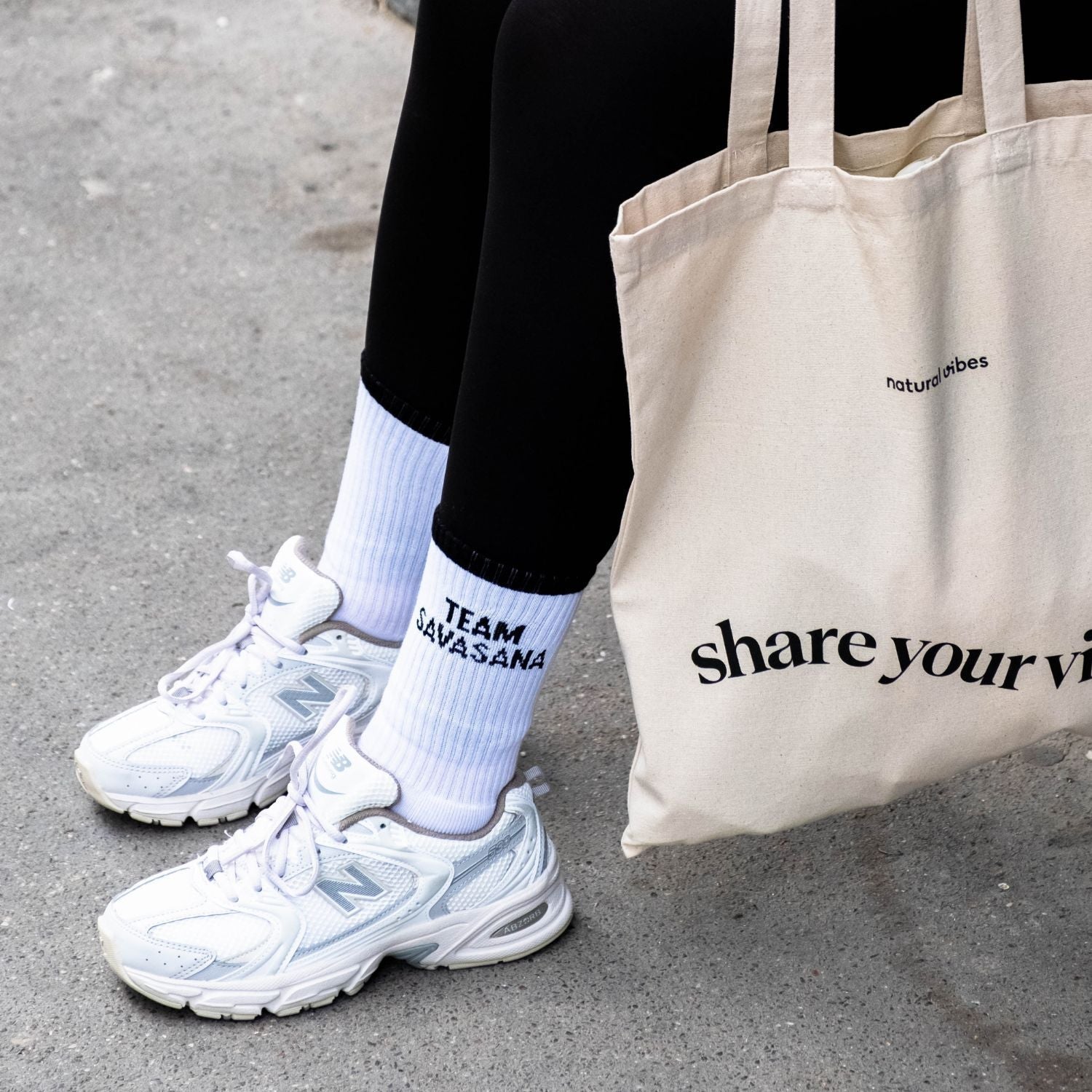 Lifestyle Photo von Person, die Team Savasana Socken mit Leggings und Sneakers trägt.. 