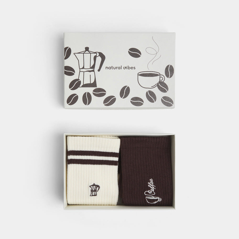 Geöffnete Coffee Geschenkbox mit zwei Paar Bio-Tennissocken bestickt mit Moka- und Kaffee-Design.