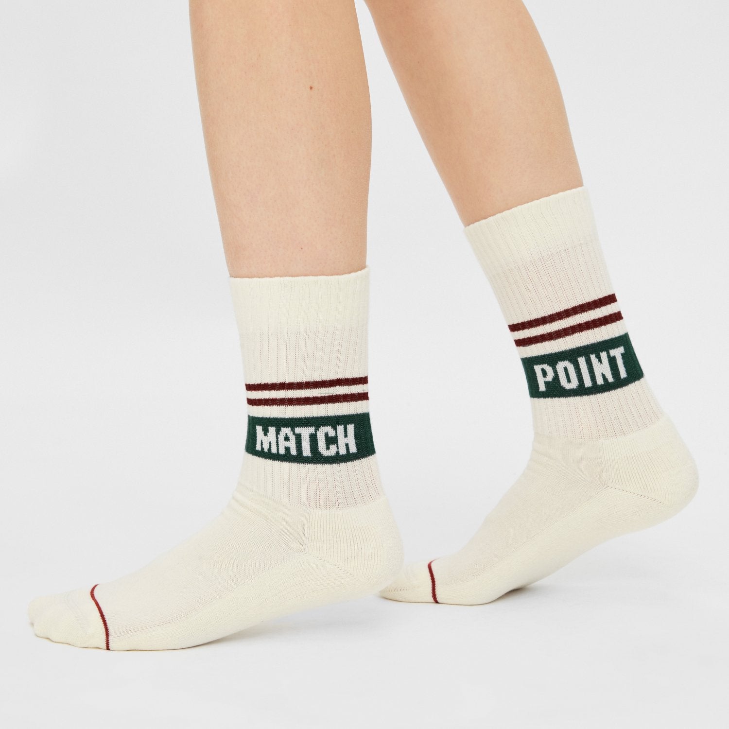 Model trägt naturweiße Tennissocken "Match Point" mit dunkelroten Streifen und Schriftzug "Match Point" - Natural Vibes Clothing