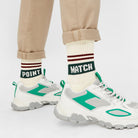 Model trägt Naturweiße Tennissocken "Match Point" mit dunkelroten Streifen und Schriftzug "Match Point" mit Sneakern - Natural Vibes Clothing