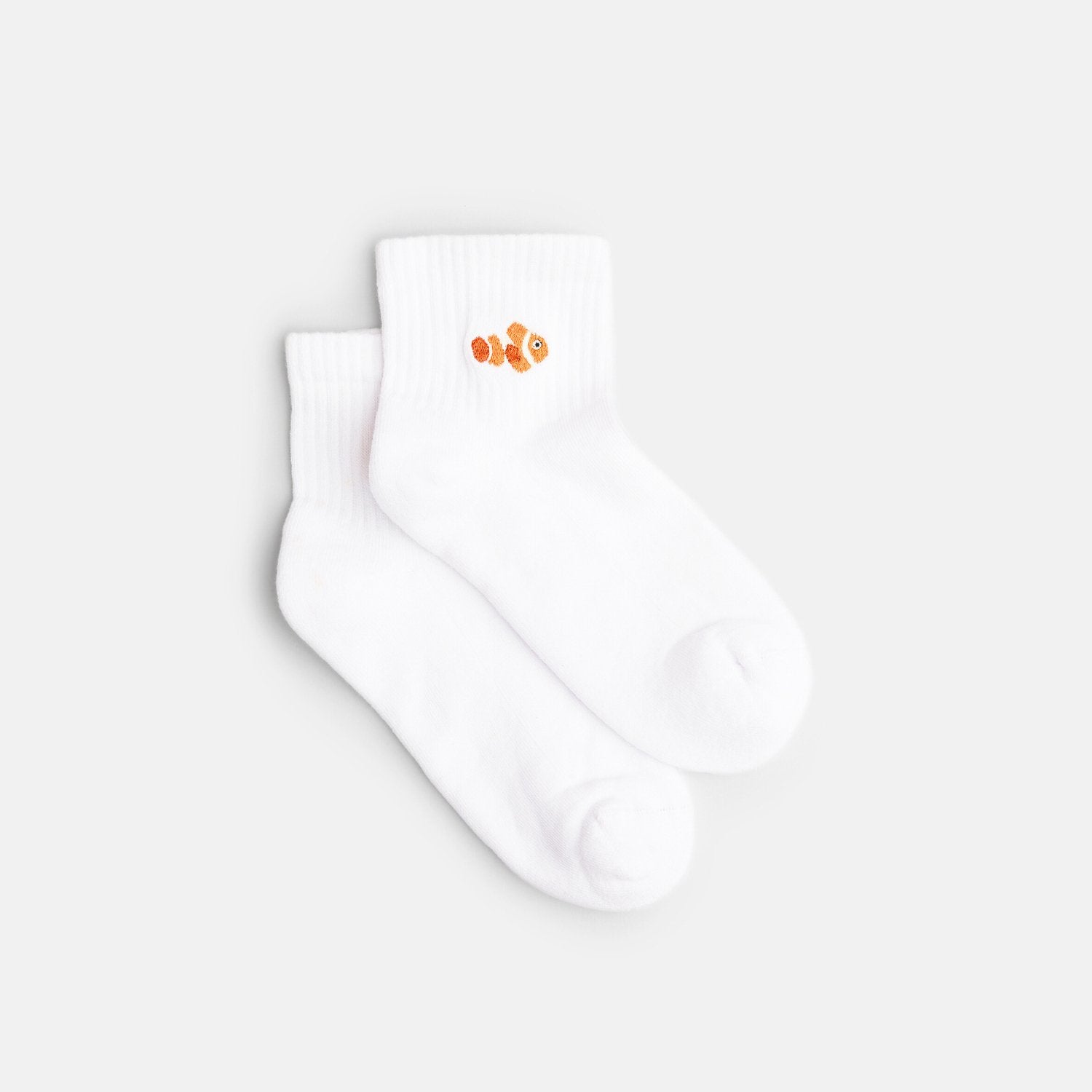 Ein Paar weiße Quarter Socken mit aufgesticktem orangenen Clownfisch aus Bio-Baumwolle – Natural Vibes Clothing