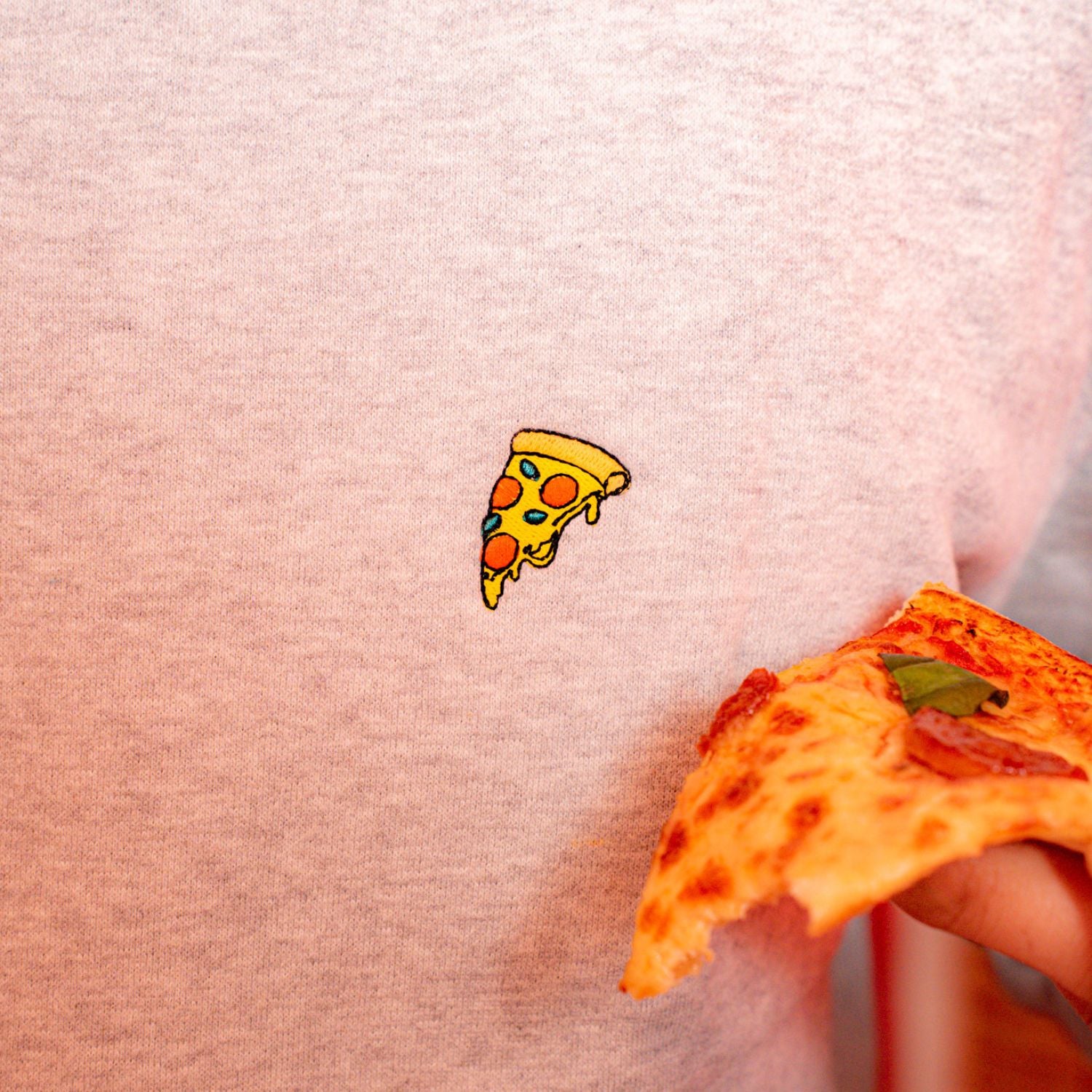 Hellgrauer Bio-Baumwoll-Sweater mit Pizzastück-Stickerei auf der Brust von Natural Vibes Clothing. 
