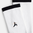 Detailansicht der Stickerei einer Person in Kriegerpose auf dem Schaft der weißen Warrior Tennissocken  – Natural Vibes Clothing