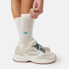 Welt Tennissocken - Natural Vibes Clothing. Naturweiße Bio-Tennissocken mit Globus-Stickerei kombiniert mit Sneakern.