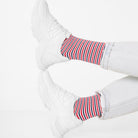 Morning Socken mit roten und blauen Streifen zu weißen Sneakern getragen. Natural Vibes Clothing
