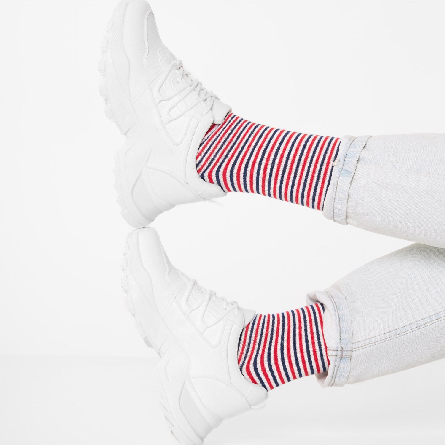 Morning Socken mit roten und blauen Streifen zu weißen Sneakern getragen. Natural Vibes Clothing