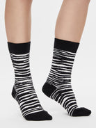 Schwarz-weiße Zebra Socken mit klassischem Animal Print am Fuß getragen.