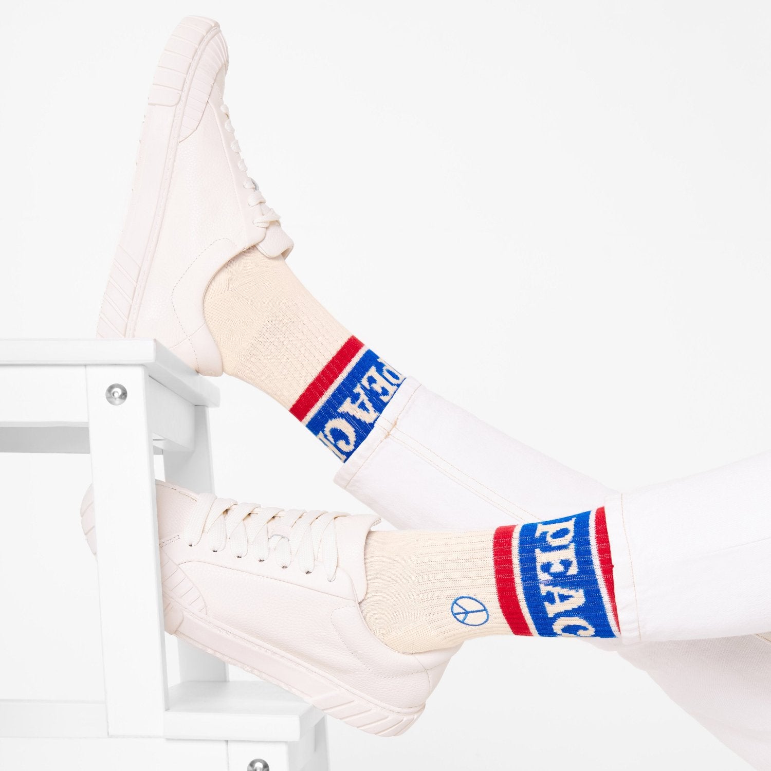 Naturweiße Bio-Tennissocken Peace & Love mit Peace-Zeichen getragen  mit weißen Sneakern im minimalistischen Lifestyle-Look – Natural Vibes Clothing